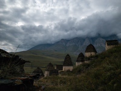 白天，白云下山附近绿草地上的棕色木栅栏
